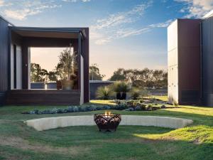 a house with a vase in the middle of a yard at Samphire Chalet Tuart - Luxury Amidst Nature in Geographe
