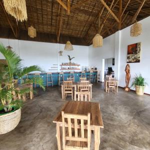 a restaurant with tables and chairs and a bar at Mahé Lodge, Nosy Be in Nosy Be