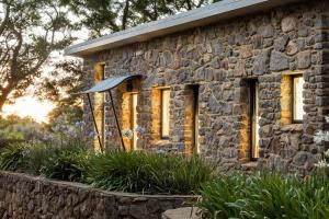 a stone building with windows in a garden at Petra Olive 2 in Yallingup