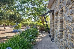 a stone wall with a metal hand rail on a walkway at Petra Olive 2 in Yallingup
