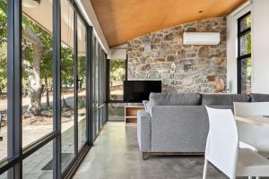 an open living room with a stone wall at Petra Olive 2 in Yallingup +11 photos