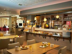 a restaurant with tables and chairs and a bar at Ibis Sarlat Centre in Sarlat-la-Canéda