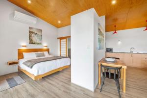 a bedroom with a bed and a desk and a kitchen at Petra Olive 5 in Yallingup +10 photos