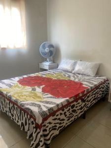a bed with a quilt on it in a bedroom at Prive Familiar e Aconchegante in Paulista