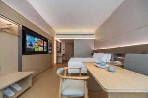 a hotel room with a bed and a desk and a tv at GH Hotel in Chengdu +19 photos