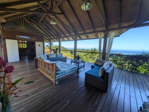 a patio with couches and a table on a wooden deck at Fare Tihi Moana in Tahu-Naoe