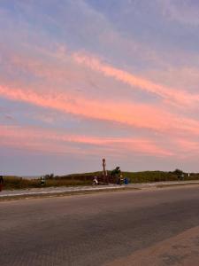 an empty street with a sunset in the sky at Pousada Boa Praia Guriri in São Mateus