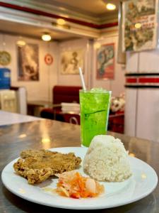 a plate of food and a drink on a table at Hotel Tiffany - Laoag in Laoag