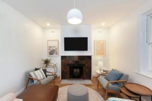 a living room with a fireplace and a flat screen tv at Lava House WIFI central heating cooling CBD in Warrnambool