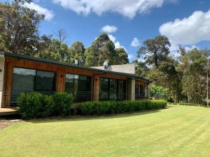 a house with a green lawn in front of it at Lake View - Contemporary Comforts meets Nature in Quindalup