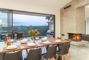 a dining room with a table and a fireplace at Lake View - Contemporary Comforts meets Nature in Quindalup