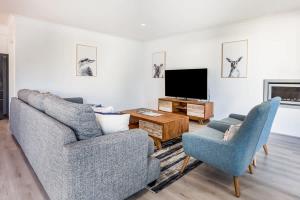 a living room with two chairs and a flat screen tv at Fernweh - A Generous Hamptons-style Beachside Escape in Geographe