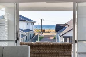 a living room with a view of the ocean at Fernweh - A Generous Hamptons-style Beachside Escape in Geographe