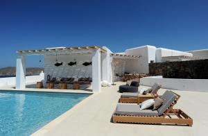 eine Villa mit einem Pool, Stühlen und einem Haus in der Unterkunft Lidia Villa in Panormos, Mykonos