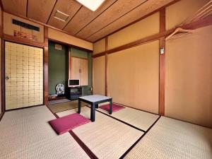 a room with a table in the middle of a room at Masugataya Ryokan in Tako