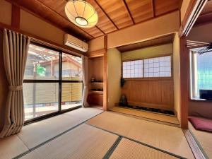 an empty room with large windows and a chandelier at Masugataya Ryokan in Tako