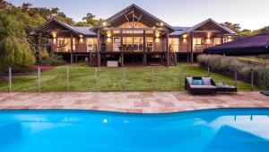 a house with a pool in front of it at Sky View - Elevated Estate with Resort-Style Pool in Yallingup