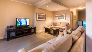 a living room with a couch and a television at Surfside 8 - Spacious Retreat on Yallingup Beach in Yallingup