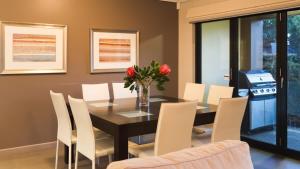 a dining room with a table and white chairs at Surfside 8 - Spacious Retreat on Yallingup Beach in Yallingup +8 photos