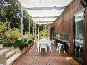 a wooden deck with a table and chairs on it at Sophie's Vineyard - Sprawling Scenery with Pool in Yallingup