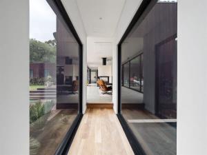 a hallway of a house with large glass windows at Sophie's Vineyard - Sprawling Scenery with Pool in Yallingup