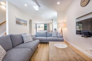 a living room with a couch and a tv at Yallingup Lagoon Beach House in Yallingup