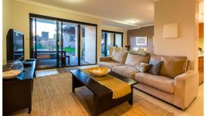 a living room with a couch and a table at Surfside 9 - In the Idyllic Yallingup Beach Scene in Yallingup