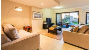 a living room with two couches and a tv at Surfside 9 - In the Idyllic Yallingup Beach Scene in Yallingup