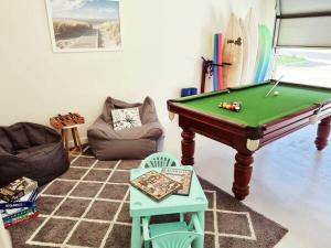 a living room with a pool table and chairs at Rabbits Break - Beachside Bliss Steps from Yallingup in Yallingup