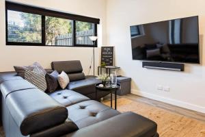 a living room with a couch and a flat screen tv at Rabbits Break - Beachside Bliss Steps from Yallingup in Yallingup