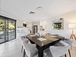 a dining room with a black table and chairs at Surfside 1 - An Unforgettable Yallingup Experience in Yallingup