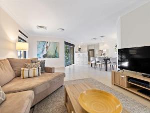a living room with a couch and a flat screen tv at Surfside 1 - An Unforgettable Yallingup Experience in Yallingup