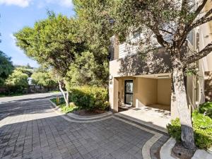 a building with a tree next to a street at Surfside 1 - An Unforgettable Yallingup Experience in Yallingup