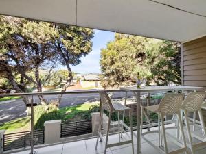 a balcony with a table and chairs and a large window at Surfside 1 - An Unforgettable Yallingup Experience in Yallingup +16 photos