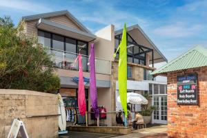 a building with colorful flags in front of it at Surfside 3A - Vibrant Yallingup Beachfront Living in Yallingup