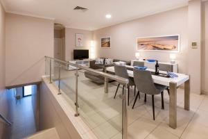 a dining room and living room with a table and chairs at Surfside 3A - Vibrant Yallingup Beachfront Living in Yallingup