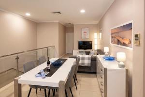 a living room with a dining table and a bedroom at Surfside 3A - Vibrant Yallingup Beachfront Living in Yallingup