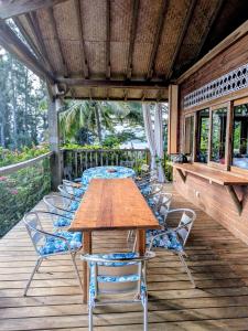 a wooden table and chairs on a deck at Fare Tihi Moana in Tahu-Naoe