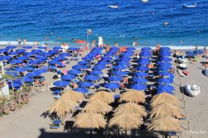 レトイアンニにあるLoft Baia di Letojanniの青い傘と椅子の群れ