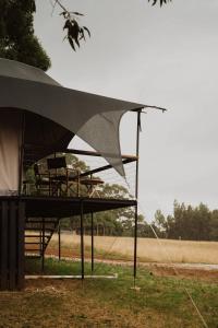 a tent with a table and chairs in a field at Wandagar Eco Tent - Baudin in Pemberton +37 photos