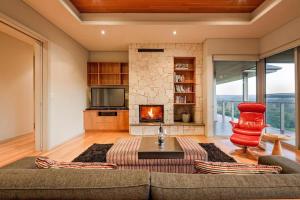 a living room with a couch and a fireplace at Valley Views - Elevated Hilltop Escape near Beaches in Yallingup +30 photos