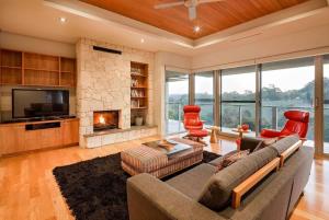 a living room with a couch and a fireplace at Valley Views - Elevated Hilltop Escape near Beaches in Yallingup