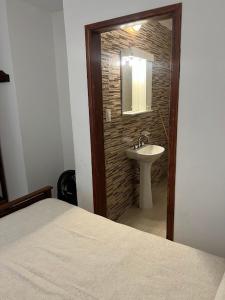 a bedroom with a bathroom with a sink and a mirror at Espacio493 in Villa Gesell