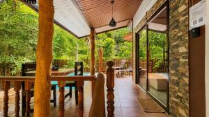 a porch of a house with a table and windows at Zen Harmony Pool Villa in Ko Phangan
