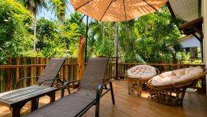 a deck with chairs and tables and an umbrella at Zen Harmony Pool Villa in Ko Phangan