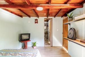 a living room with wooden ceilings and a tv at Cabaa el Sol Medellin in Titiribí