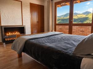 a bedroom with a bed and a fireplace with a view at Villa Luz Hotel in Silvia