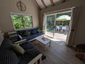 a living room with a couch and an umbrella at Cape St Francis Beach Cottage in Cape St Francis