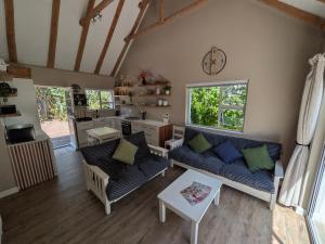 a living room with couches and a clock on the wall at Cape St Francis Beach Cottage in Cape St Francis