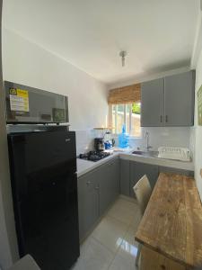 a kitchen with a black refrigerator and a wooden table at Blue Flamingo Kite Beach in Cabarete